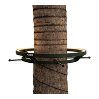 Green metal tree strap with a gold accent loop, mounted against a textured brown tree trunk.