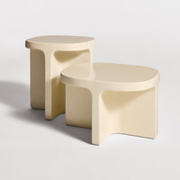 Minimalist cream-colored side tables with smooth, rounded edges and a glossy finish. Perfect for modern decor.