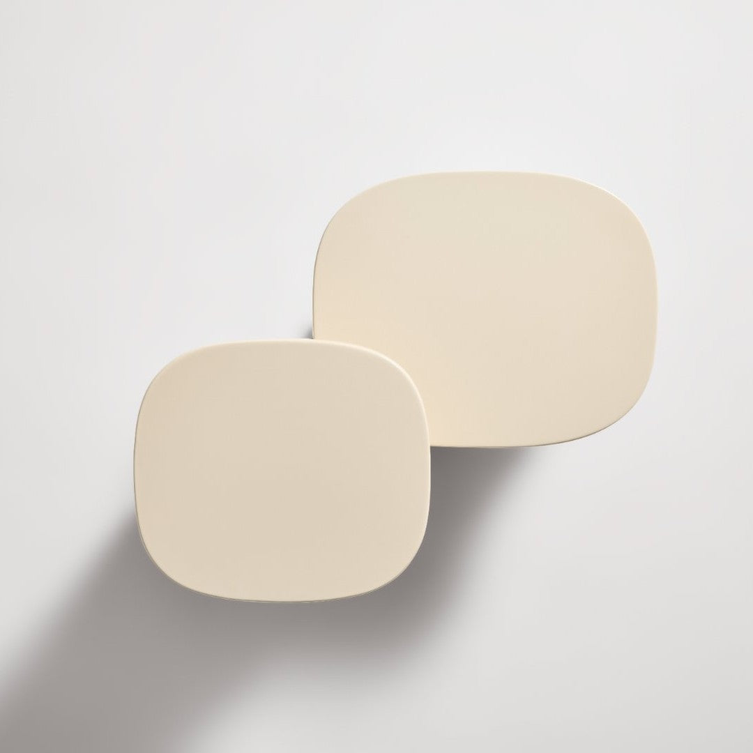"Two minimalist plates in soft beige with smooth, rounded edges, set against a light background."