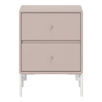 Blush pink nightstand with minimalist design and sleek white legs, featuring smooth finish and subtle round knobs.