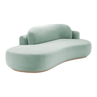 Soft green curved sofa with a smooth, velvety finish and minimalist, contemporary design. Perfect for modern interiors.