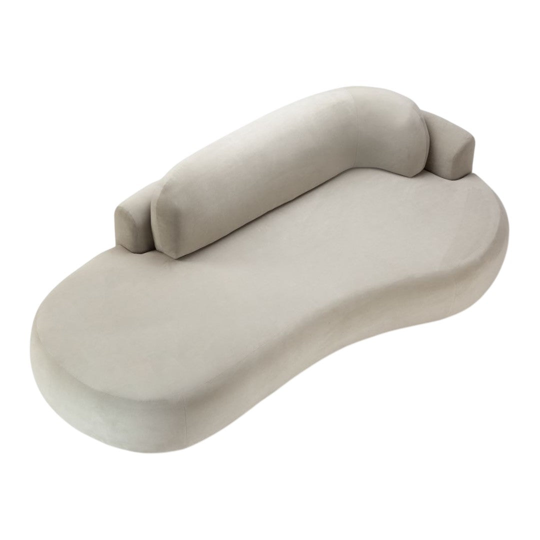 Soft beige curved chaise lounge with smooth, minimalist design and plush backing for comfort. Perfect for modern spaces.