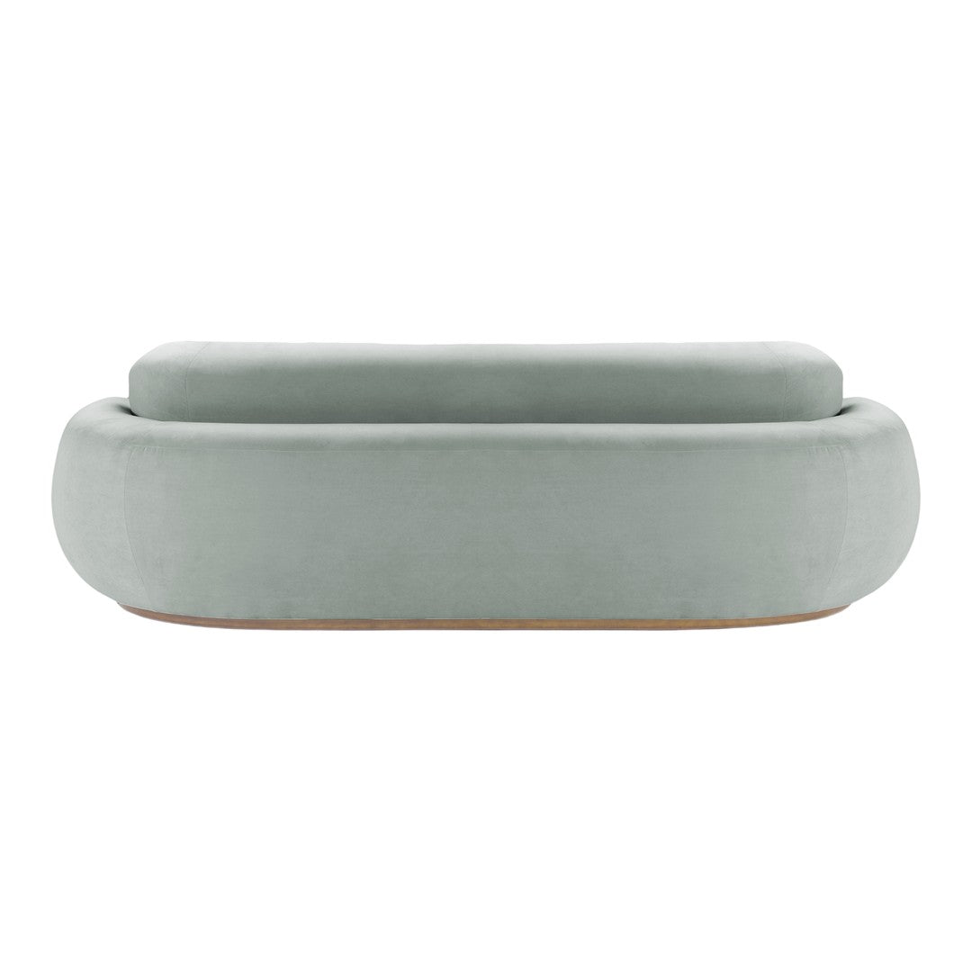 Soft green velvet ottoman with smooth, rounded edges and minimalist design. Perfect for modern decor.