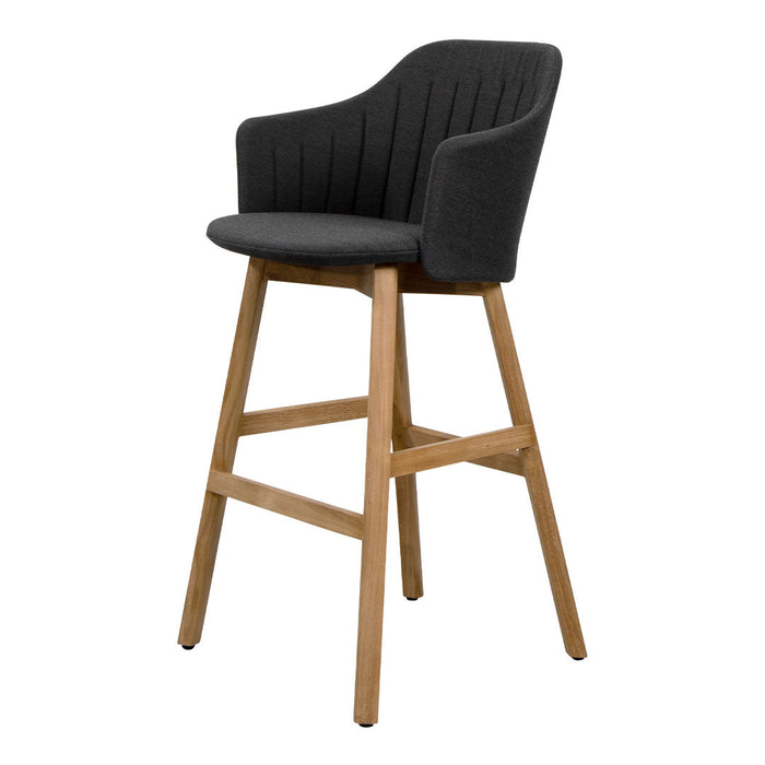 Black upholstered bar stool with vertical ribbed pattern and natural wood legs, combining modern and classic styles.