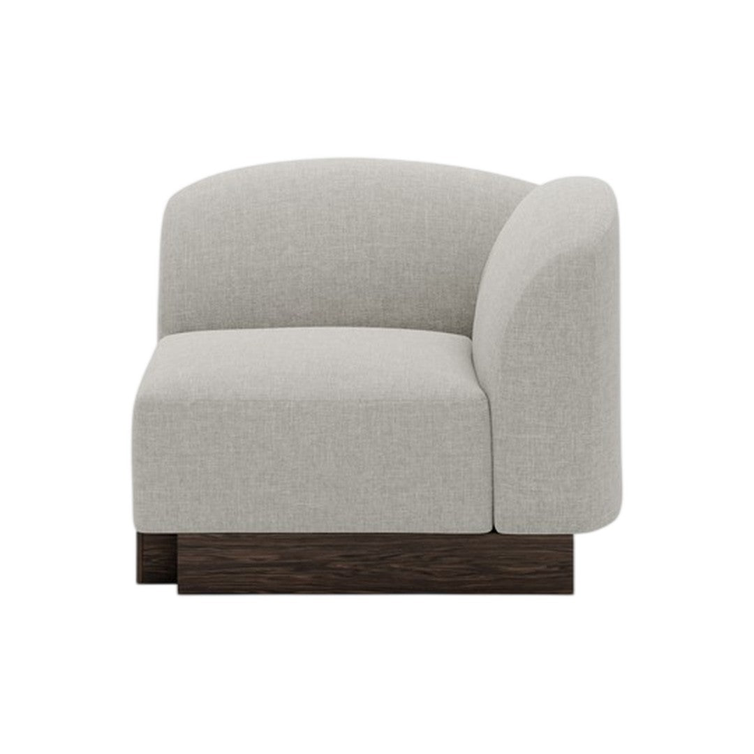 Light gray upholstered corner chair with a smooth, rounded design and dark wooden base, perfect for modern decor.