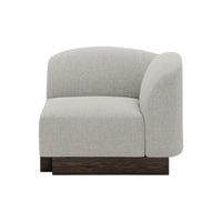 Light gray upholstered corner chair with a smooth, rounded design and dark wooden base, perfect for modern decor.