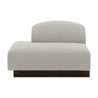 Light gray upholstered chaise lounge with a smooth fabric texture and a dark wood base. Modern, minimalist design.