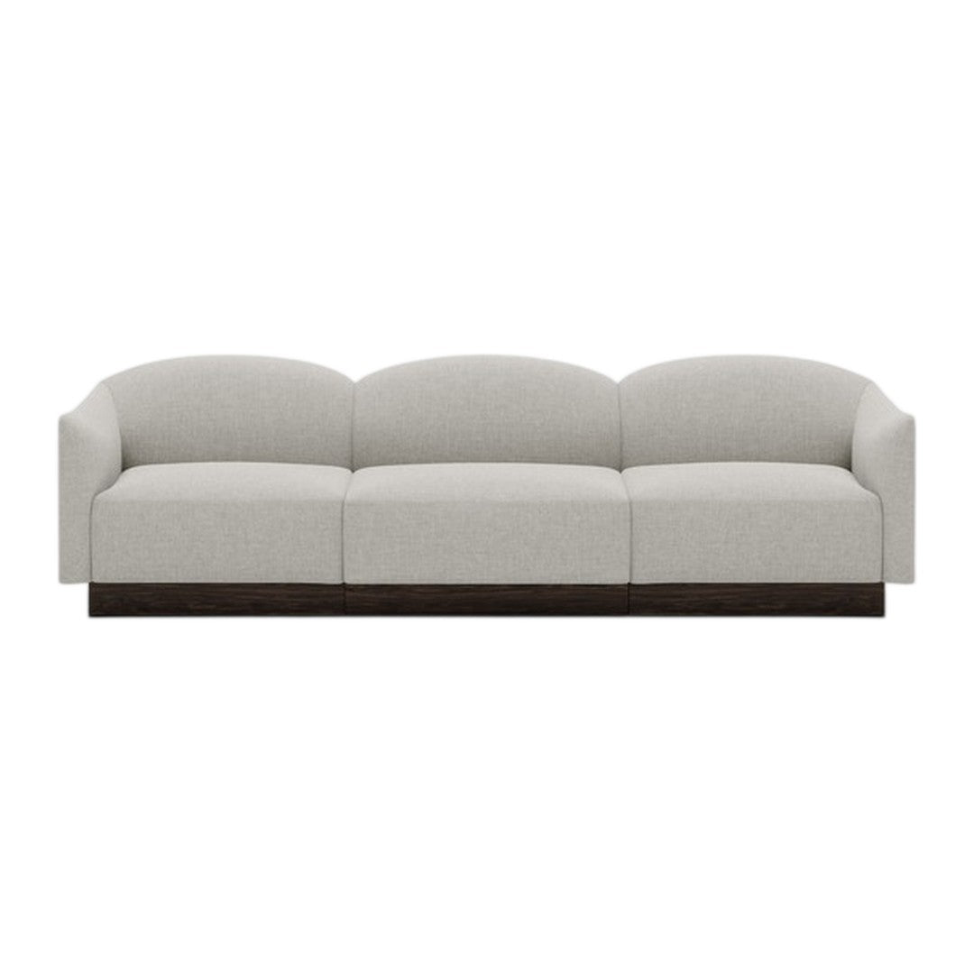 Light gray upholstered sofa with rounded cushions and a dark wood base, featuring a minimalist design.