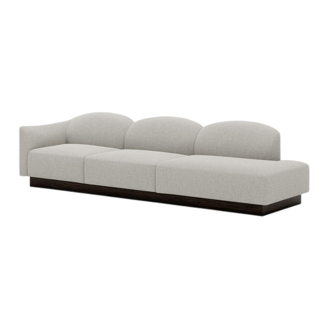 Light gray curved sofa with a smooth fabric texture and dark wood base, perfect for modern living spaces.
