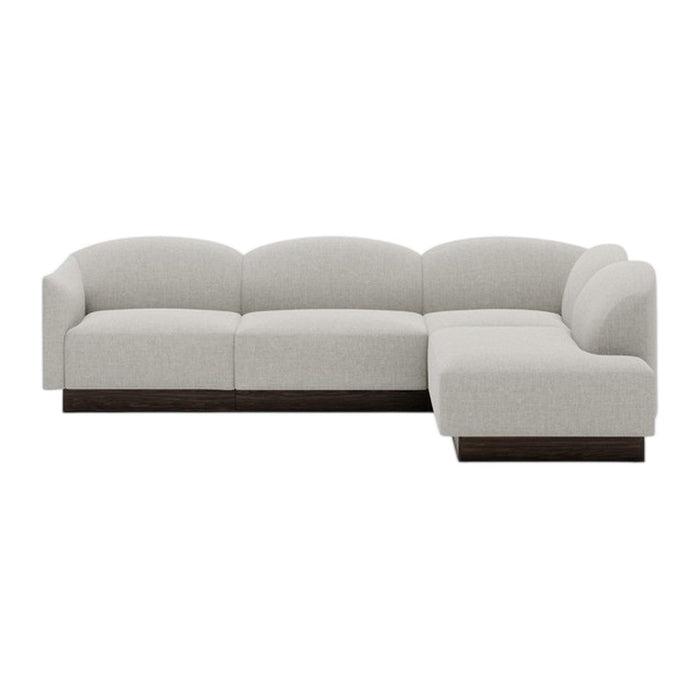 Light gray upholstered sectional sofa with smooth, rounded edges and a dark wood base. Modern minimalist design.