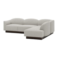 Light gray sectional sofa with curved lines and a smooth fabric texture, featuring a wood base for a modern aesthetic.