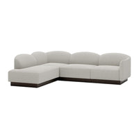 Light gray sectional sofa with smooth, curved cushions and dark wood base. Modern, minimalist design.