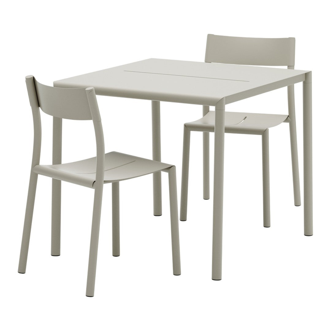 Light grey dining table and two matching chairs with a minimalist design and smooth, solid surfaces.