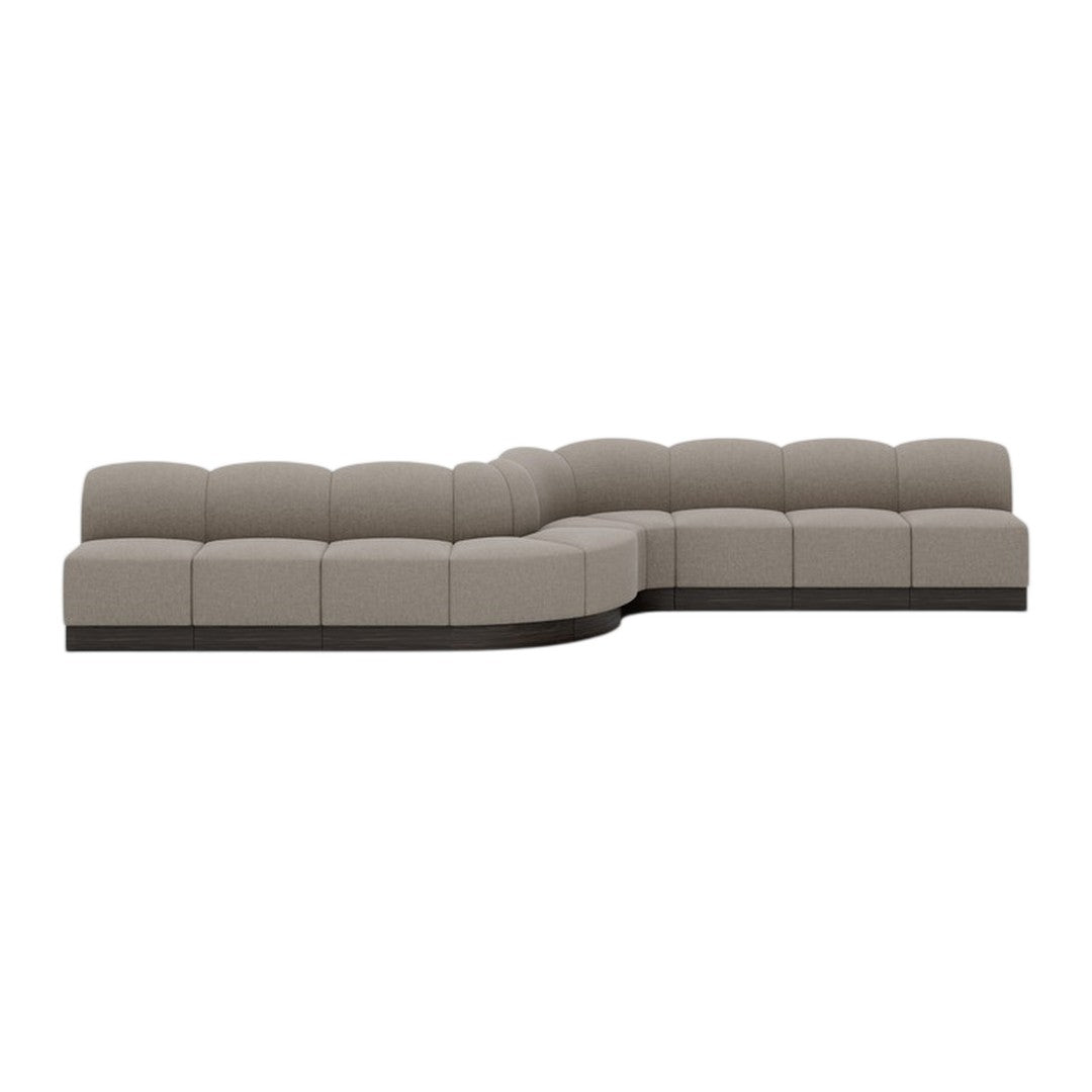 Modern sectional sofa in soft taupe upholstery with a smooth, curved silhouette and contrasting dark base.