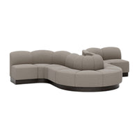 Curved sectional sofa in soft taupe fabric with smooth, rounded edges and dark wood base for a modern look.