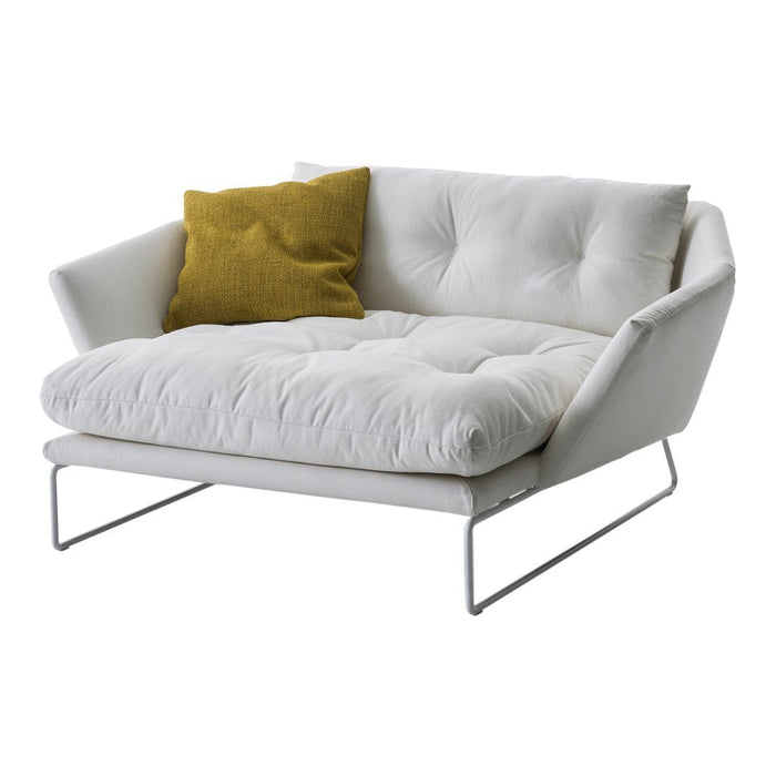 White tufted loveseat with a plush design and a textured mustard-yellow accent pillow. Modern minimalistic style.