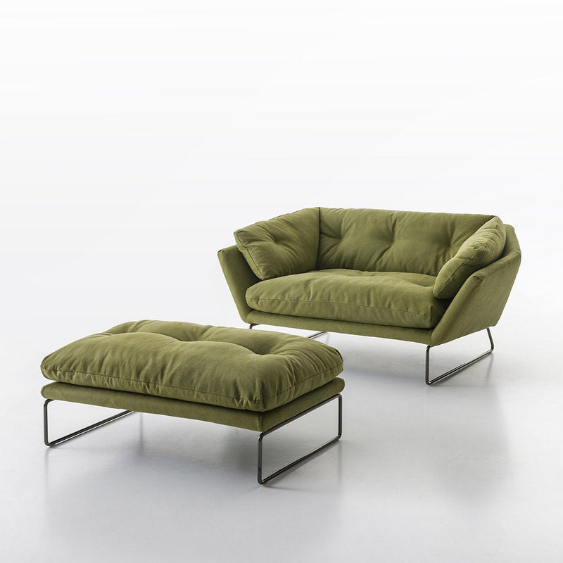 Olive green tufted sofa and ottoman with sleek metal legs, perfect for a contemporary living room style.