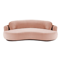 Curvy blush pink sofa with soft, smooth velvet upholstery, perfect for stylish indoor decor.