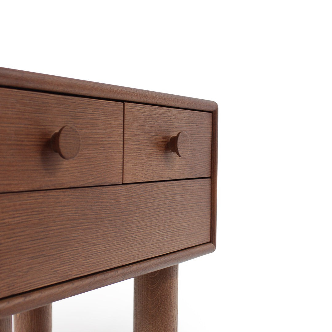 Brown wooden dresser with a smooth finish and minimalist design, featuring two drawers and round knobs.