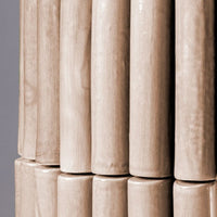 Light beige ceramic rods with a smooth, glossy finish, featuring vertical alignment and subtle natural grain patterns.