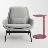 Gray upholstered chair with a black frame and pink side table featuring a round top, sleek modern design.
