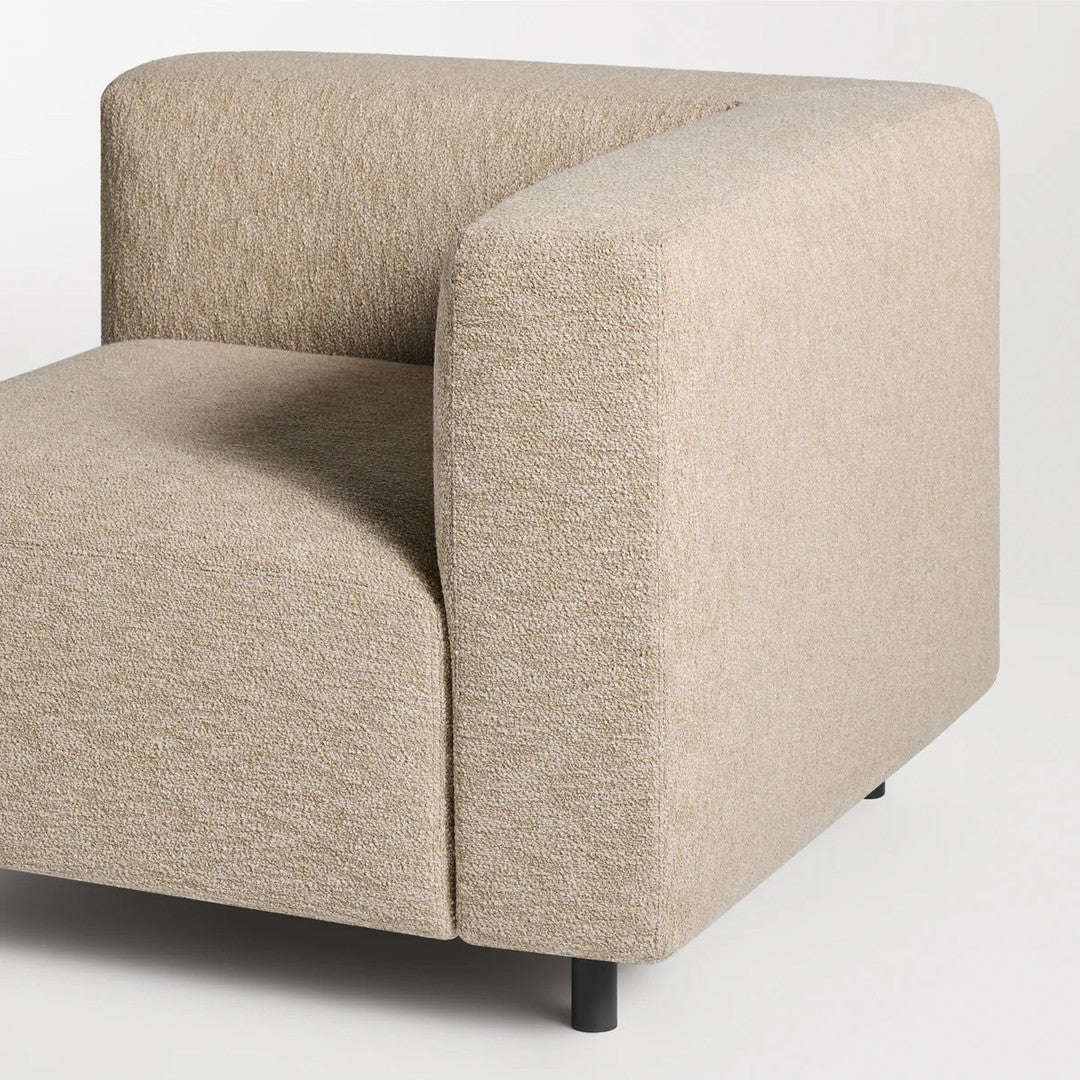 Beige textured couch corner with a soft, subtle pattern, showcasing modern, minimalist design.