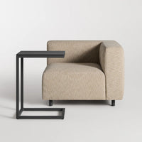 Beige textured armchair with modern black C-shaped side table, perfect for contemporary decor.