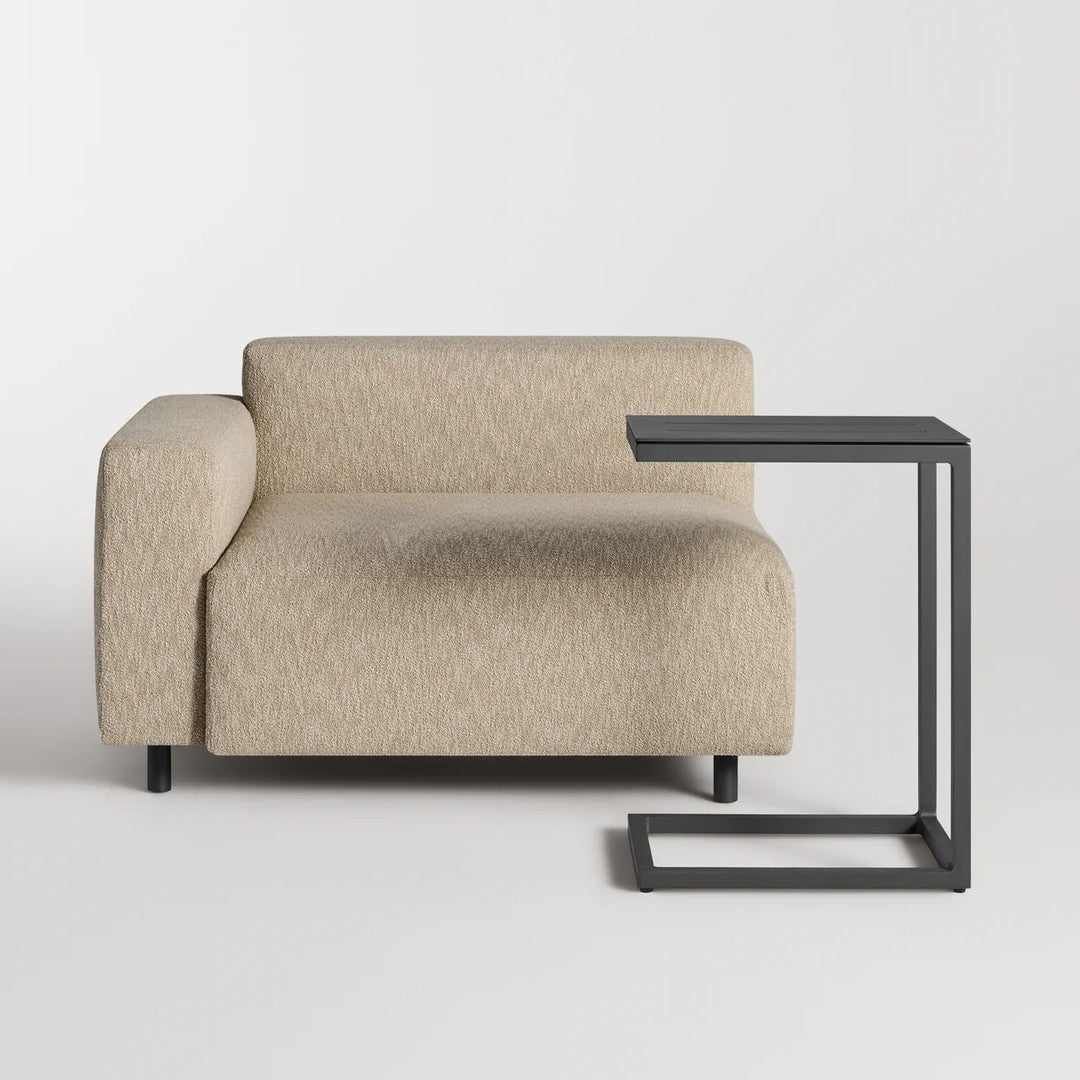 Light beige upholstered sofa with a textured pattern and a minimalist black side table.