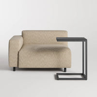 Light beige upholstered sofa with a textured pattern and a minimalist black side table.