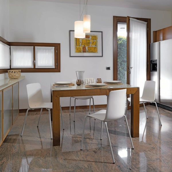 Modern dining room featuring a wooden table and white chairs on polished marble flooring, with soft white walls and subtle artwork.