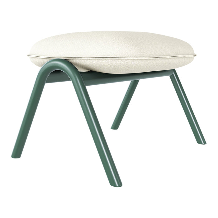 Green metal legs support a cream textured cushion, showcasing a modern and minimalist design.