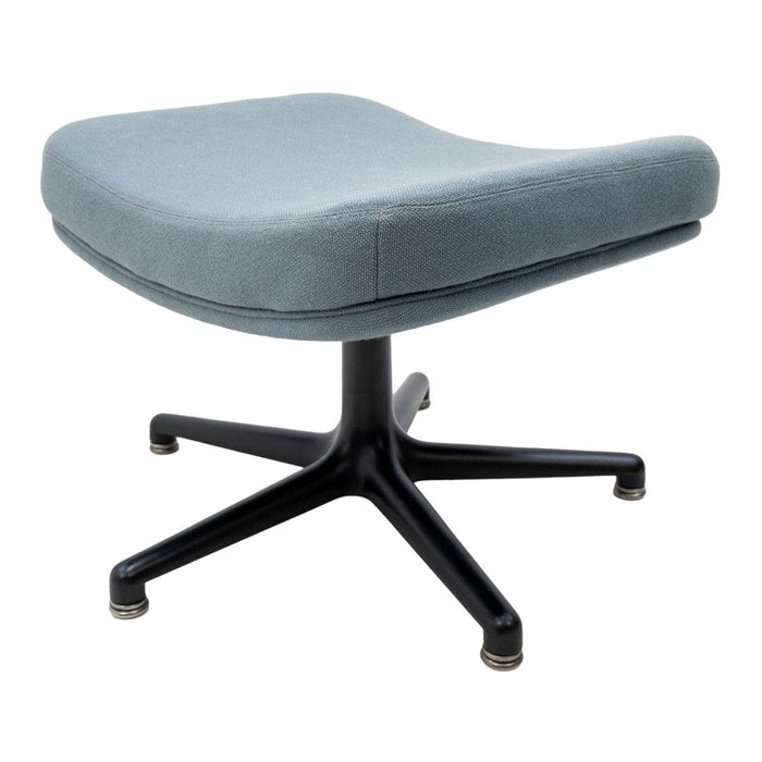 Light blue upholstered stool with a smooth texture and a sleek black star-shaped base.