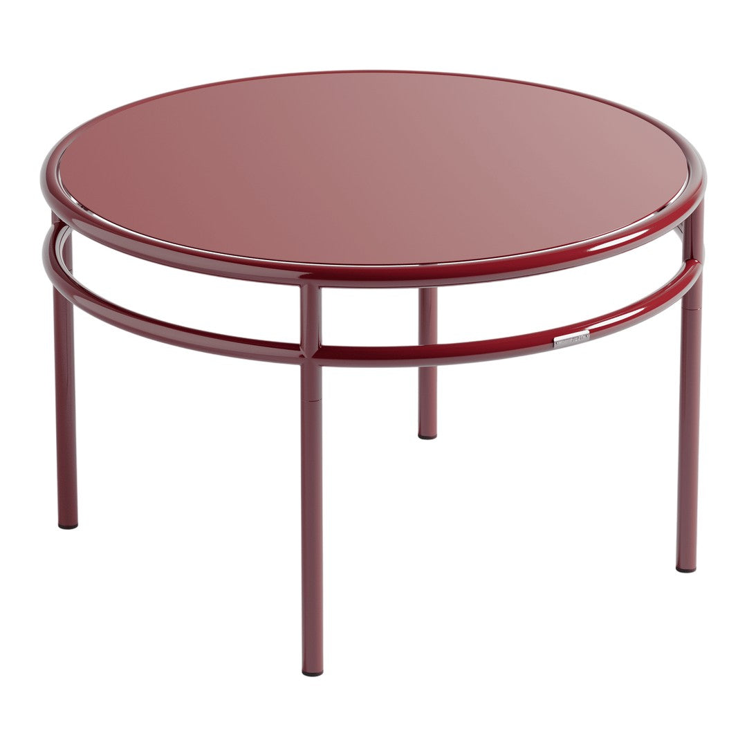 Round, glossy burgundy coffee table with minimalist design and sleek metal frame. Perfect for modern decor.