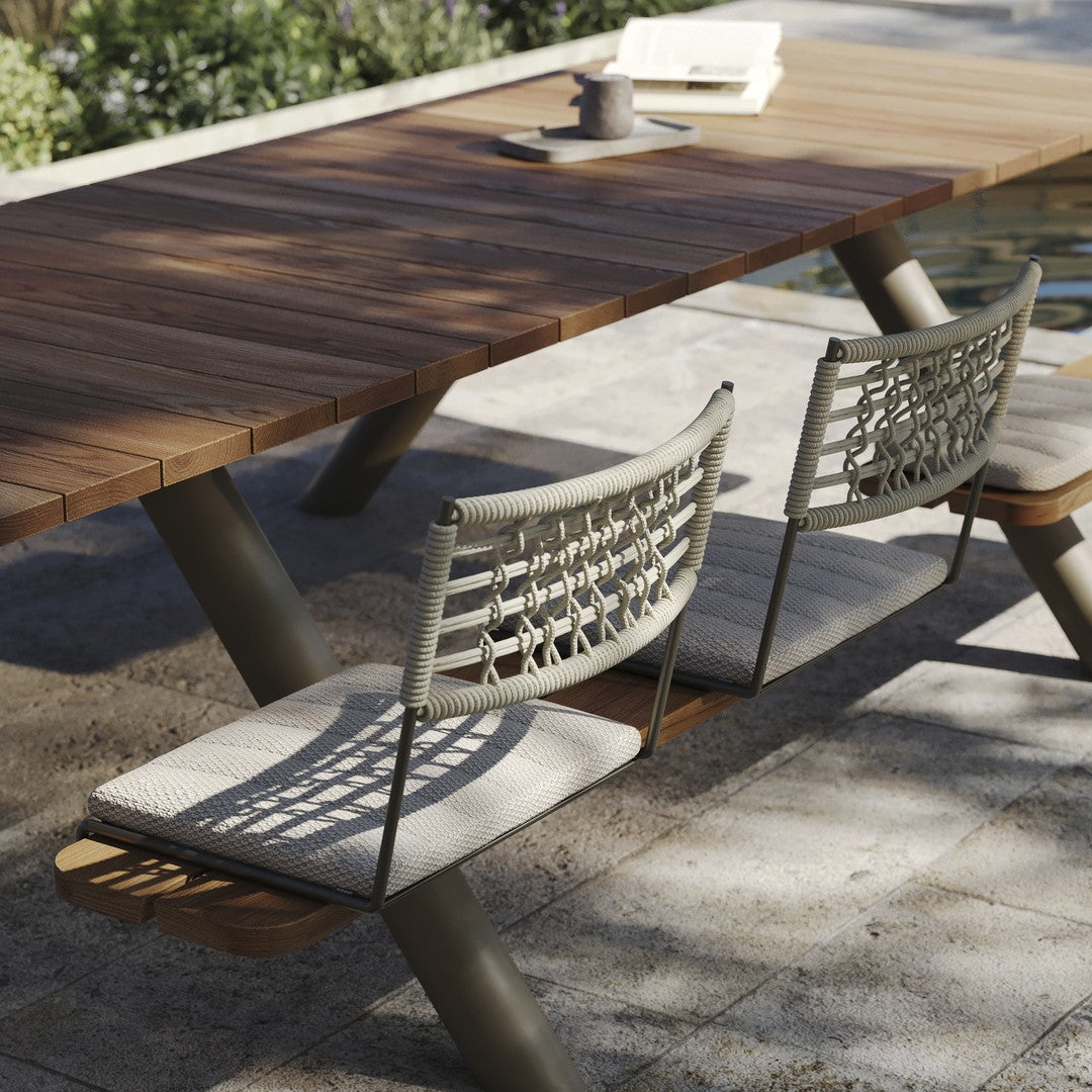 Natural wood table with gray woven fabric chairs, featuring a modern design and warm earthy tones. Perfect for outdoor settings.