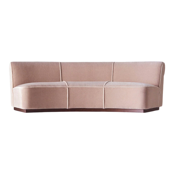 Blush pink velvet sofa with smooth, curved lines and subtle stitching details, perfect for modern interiors.