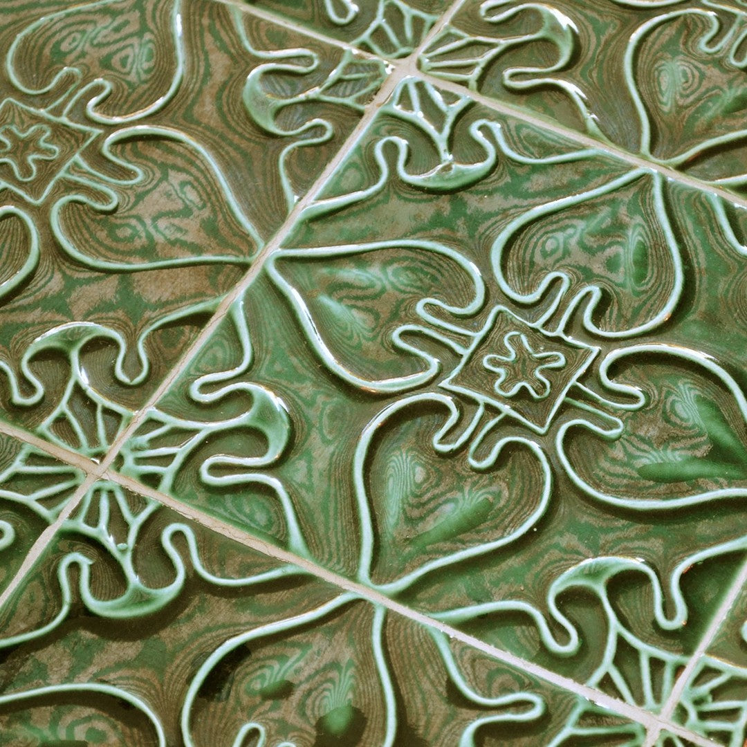 Green and cream decorative tile with intricate floral and geometric patterns for stylish flooring or backsplash.