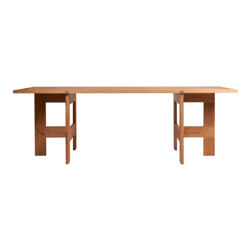 Natural wood dining table with a smooth finish, featuring minimalist design and clean lines in warm brown tones.