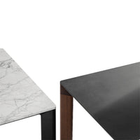 Marble and sleek black table surfaces with contrasting wood accents, showcasing elegant modern design.