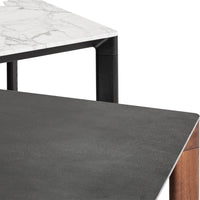 "Close-up of a modern table featuring a black surface, white marble top, and sleek geometric patterns."
