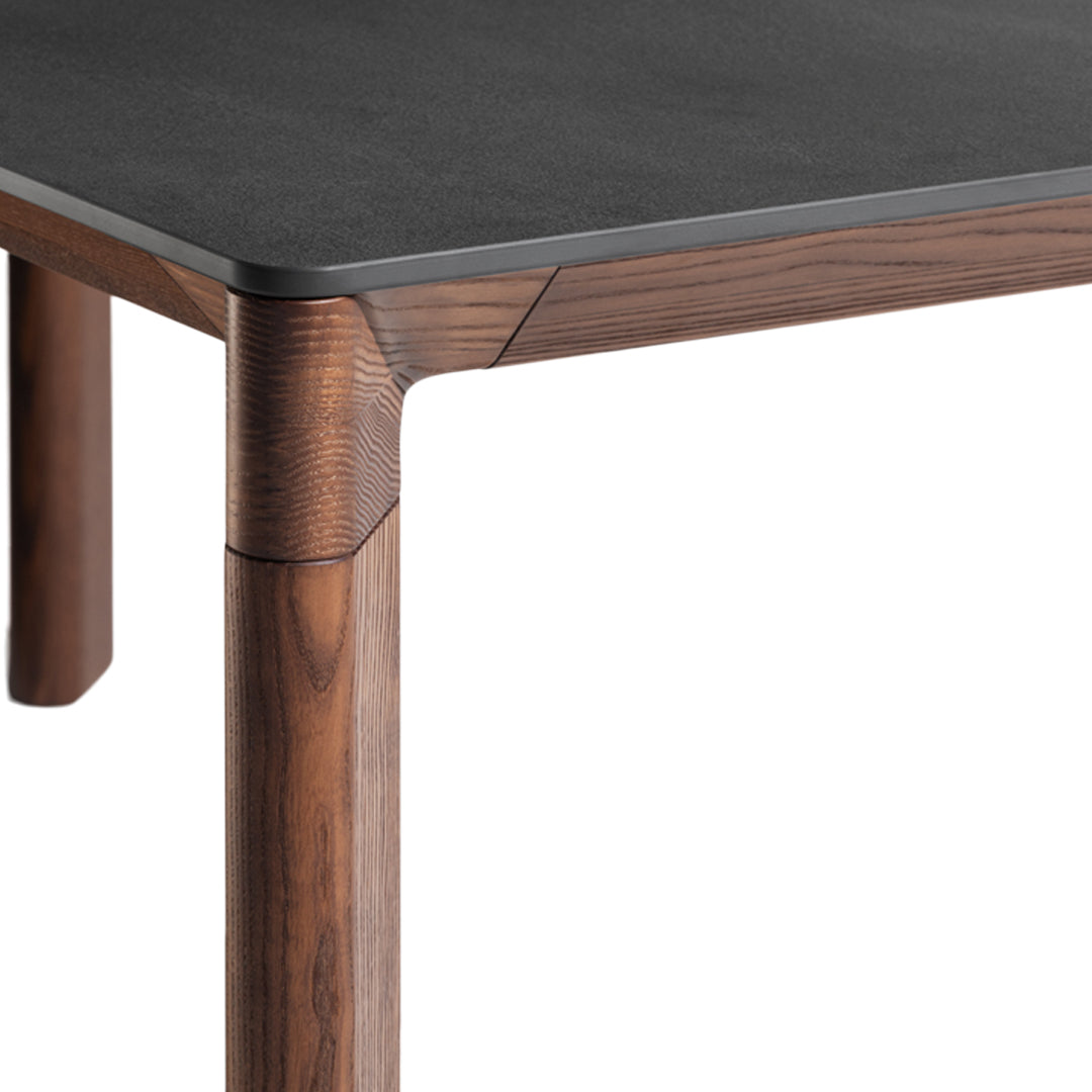 Black tabletop with walnut wood legs featuring a smooth, modern design and subtle geometric patterns.