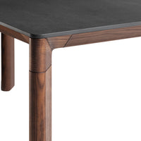 Black tabletop with walnut wood legs featuring a smooth, modern design and subtle geometric patterns.