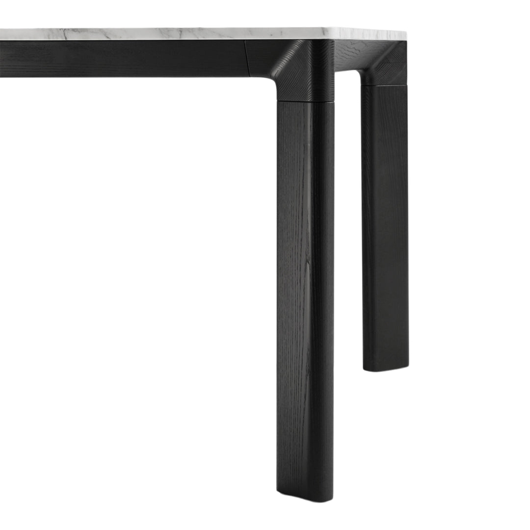 Black table legs with a sleek, modern design and a contrasting light marble top. Simple and elegant color palette.