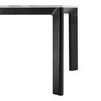 Black table legs with a sleek, modern design and a contrasting light marble top. Simple and elegant color palette.
