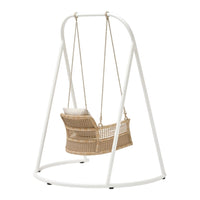 White metal frame swinging chair with a natural woven rattan seat and soft neutral pillow, perfect for outdoor spaces.