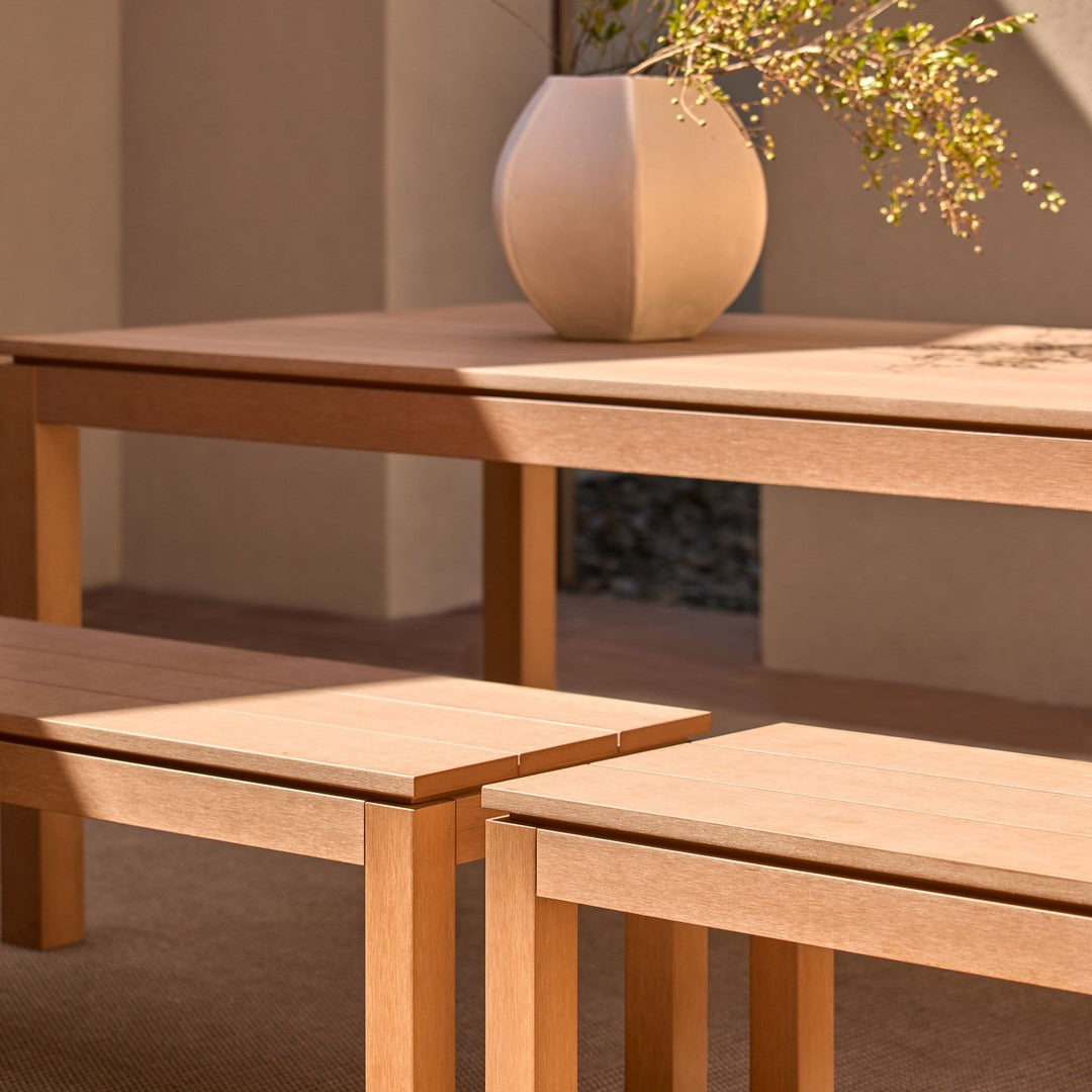 Light wood dining table and benches with a smooth finish, featured in a warm, natural color palette.