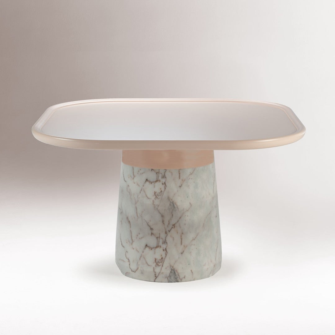Elegant table featuring a smooth pink top and a polished marble base with subtle gray and white veining.