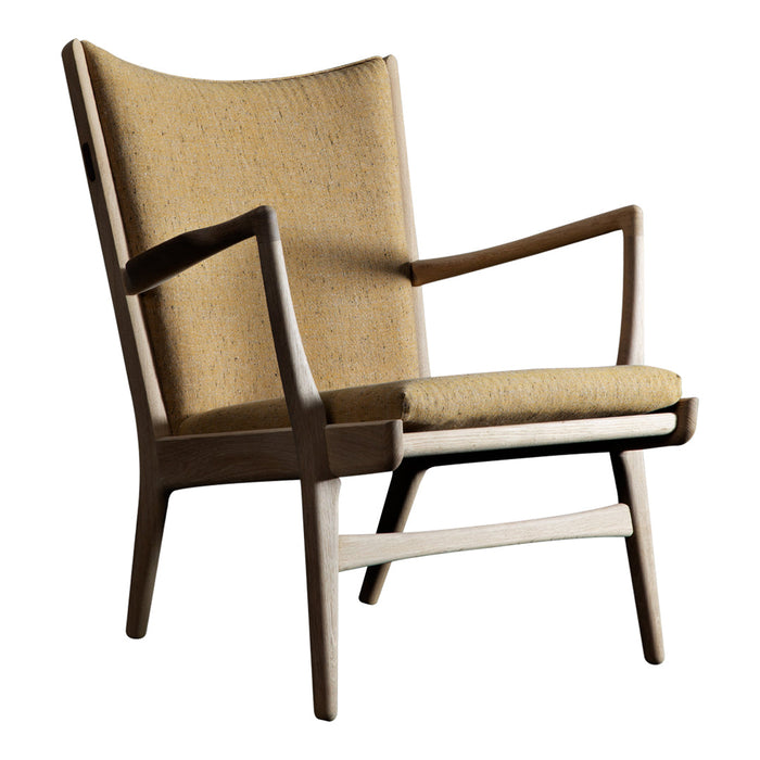 Mid-century modern chair in warm mustard yellow fabric with contrasting dark wood frame and smooth lines.