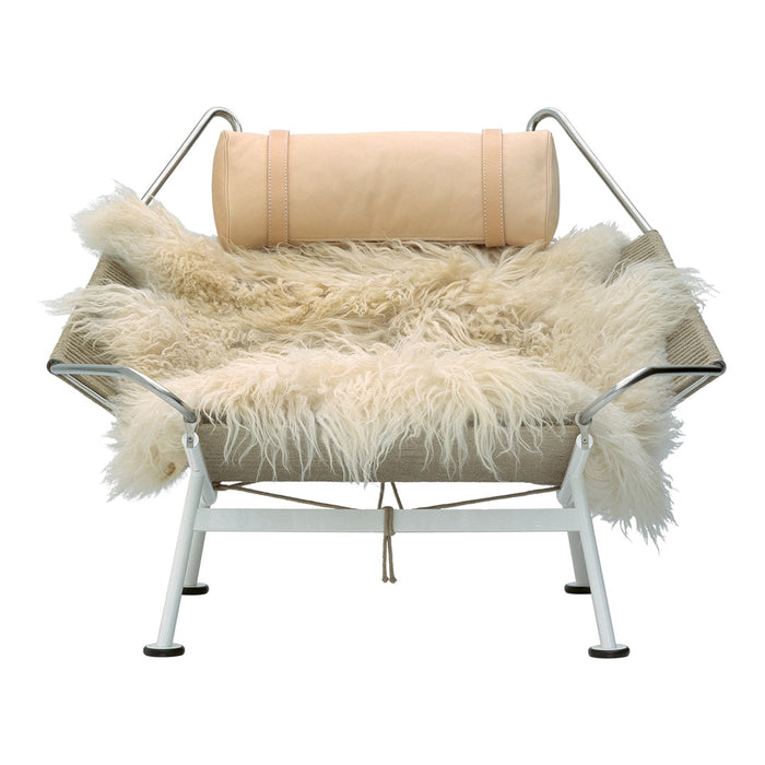 Cozy beige shearling seat with a cream cushion, set on a sleek white frame, creating a neutral, modern aesthetic.