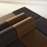 Modern modular sofa with dark brown and tan cushions, featuring a sleek geometric pattern.