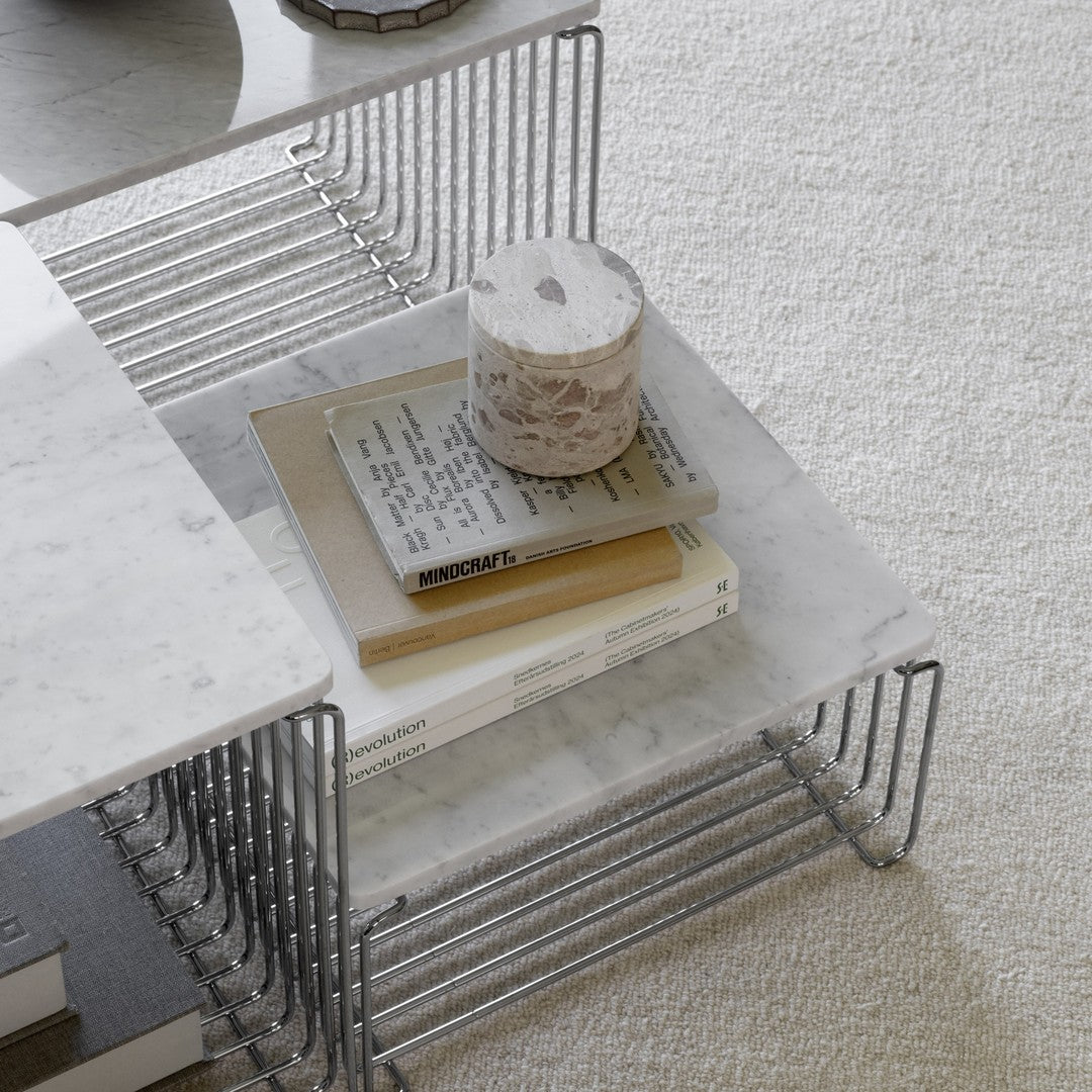 Modern marble coffee table with a sleek metal wire frame, featuring neutral tones and a minimalist design.
